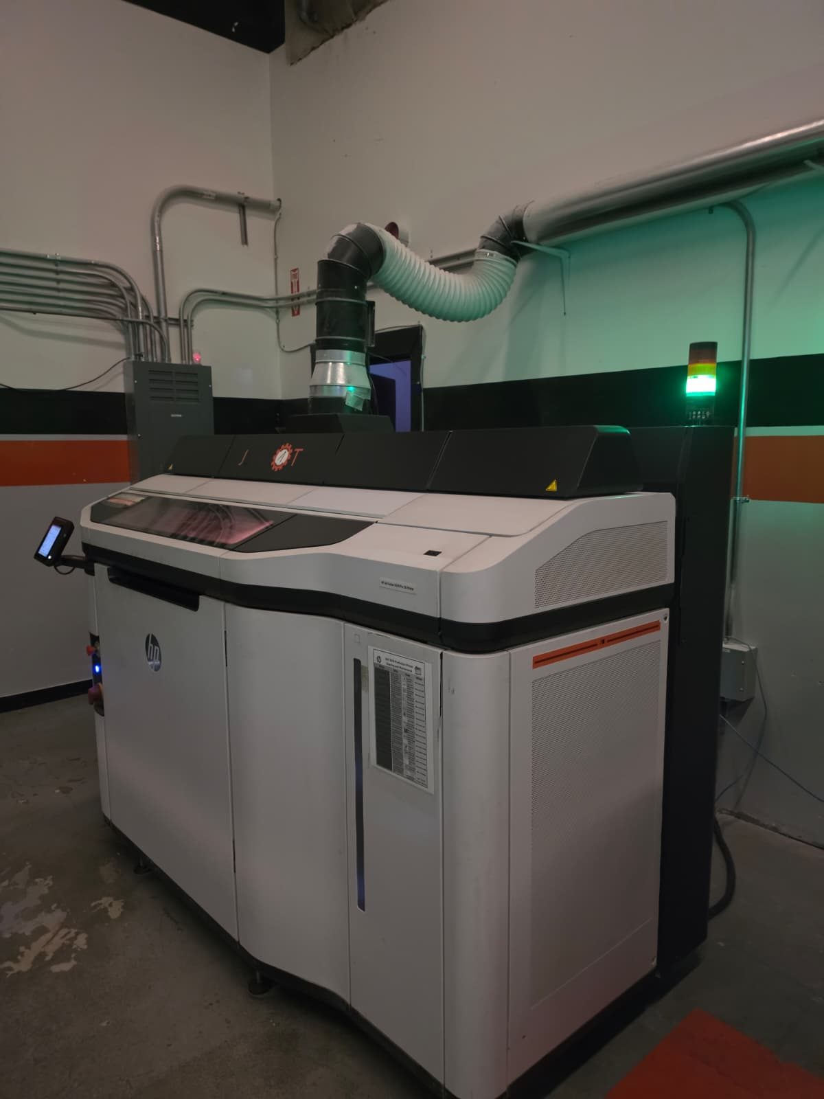 HP Multi Jet Fusion industrial 3D printer with status light on the production floor