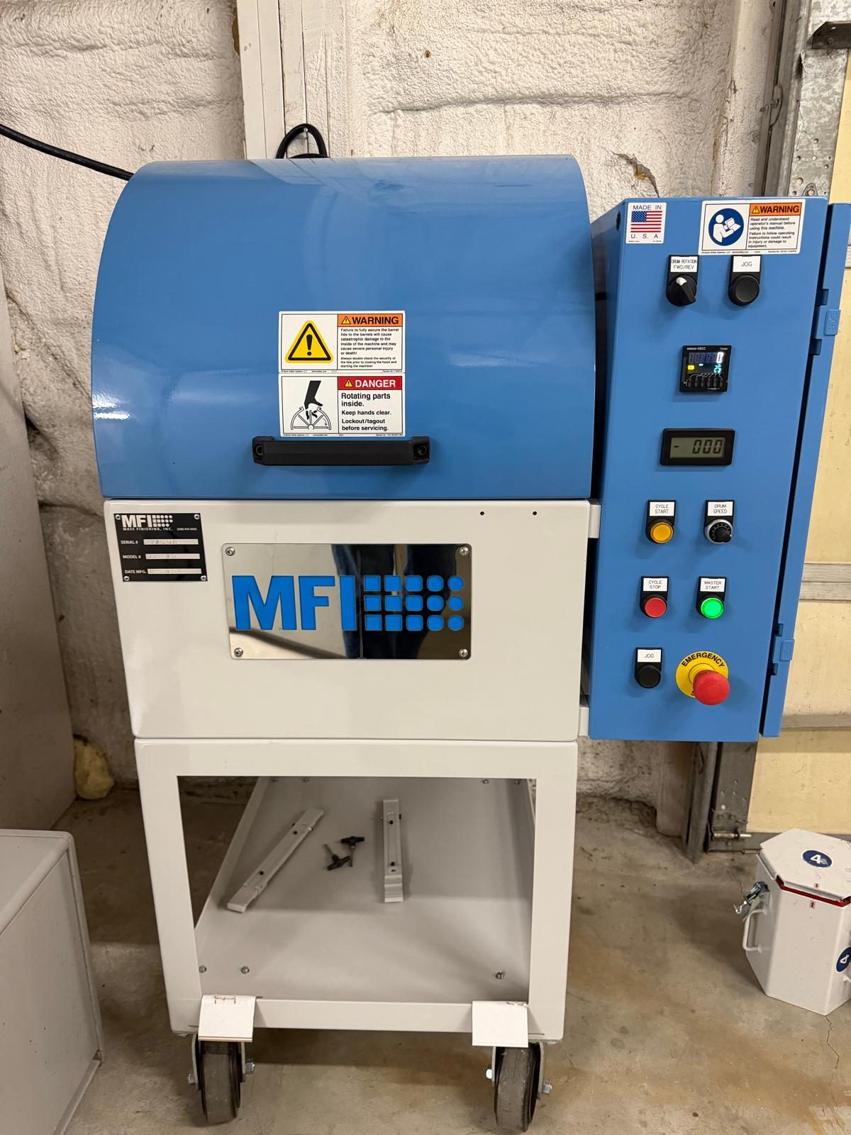MFI barrel tumbler on the finishing bench, drum hood closed and control panel lit